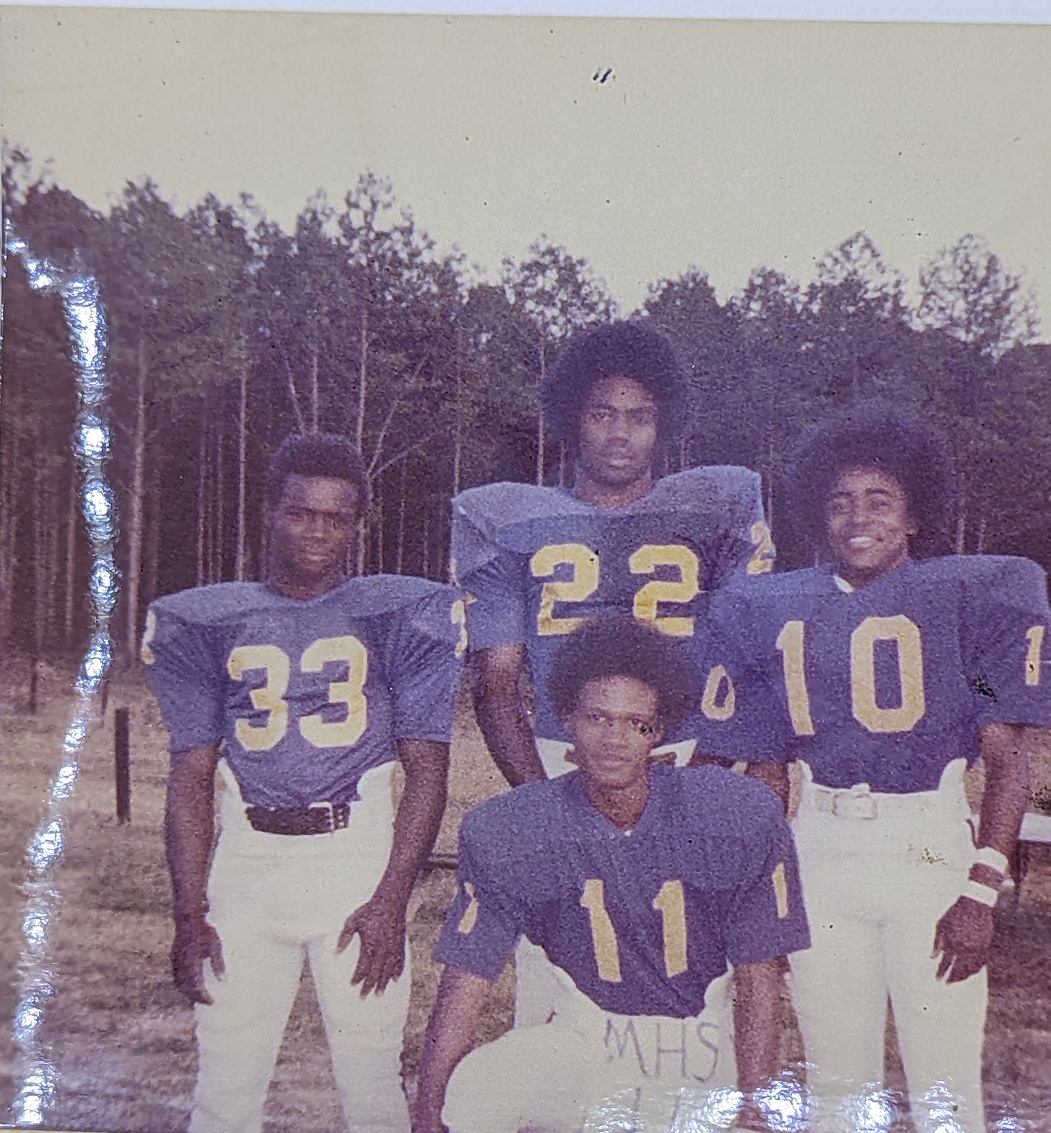Four Football Players Pose Together